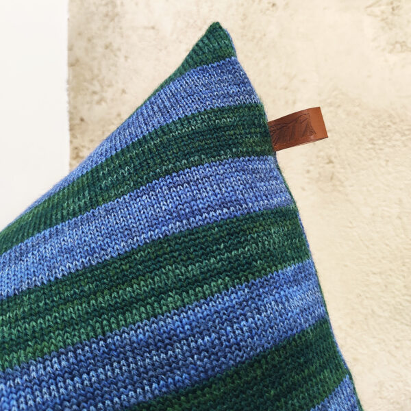 Détail d'un coussin berlingot à rayures en maille tricotée. Coussin de décoration design original et géométrique, rembourré en pure laine bretonne